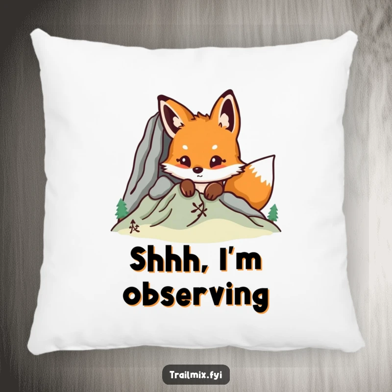 Funny fox peeking from behind a mountain graphic on a cozy pillow, adding humor and charm to home decor.