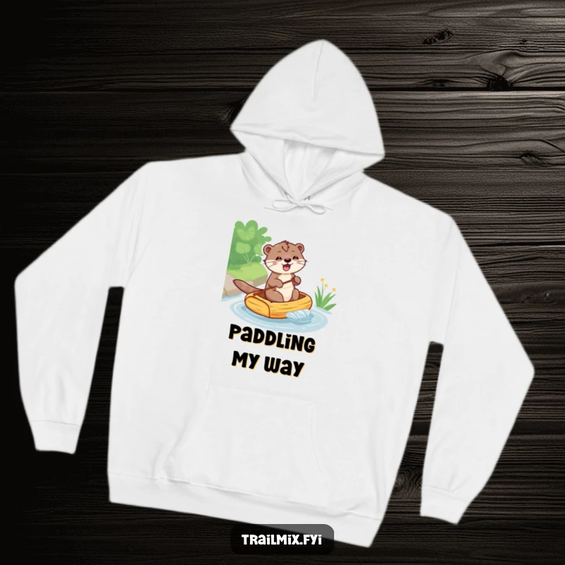 Funny hoodie showcasing a grinning otter navigating a petite raft down a flowing stream, perfect for cozy, humorous wear.