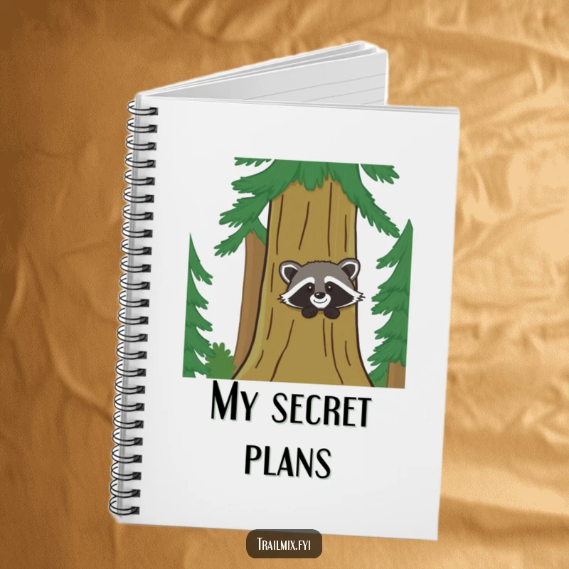 Funny notebook shows a playful raccoon peeking from a pine tree, inspiring notes with woodland humor.
